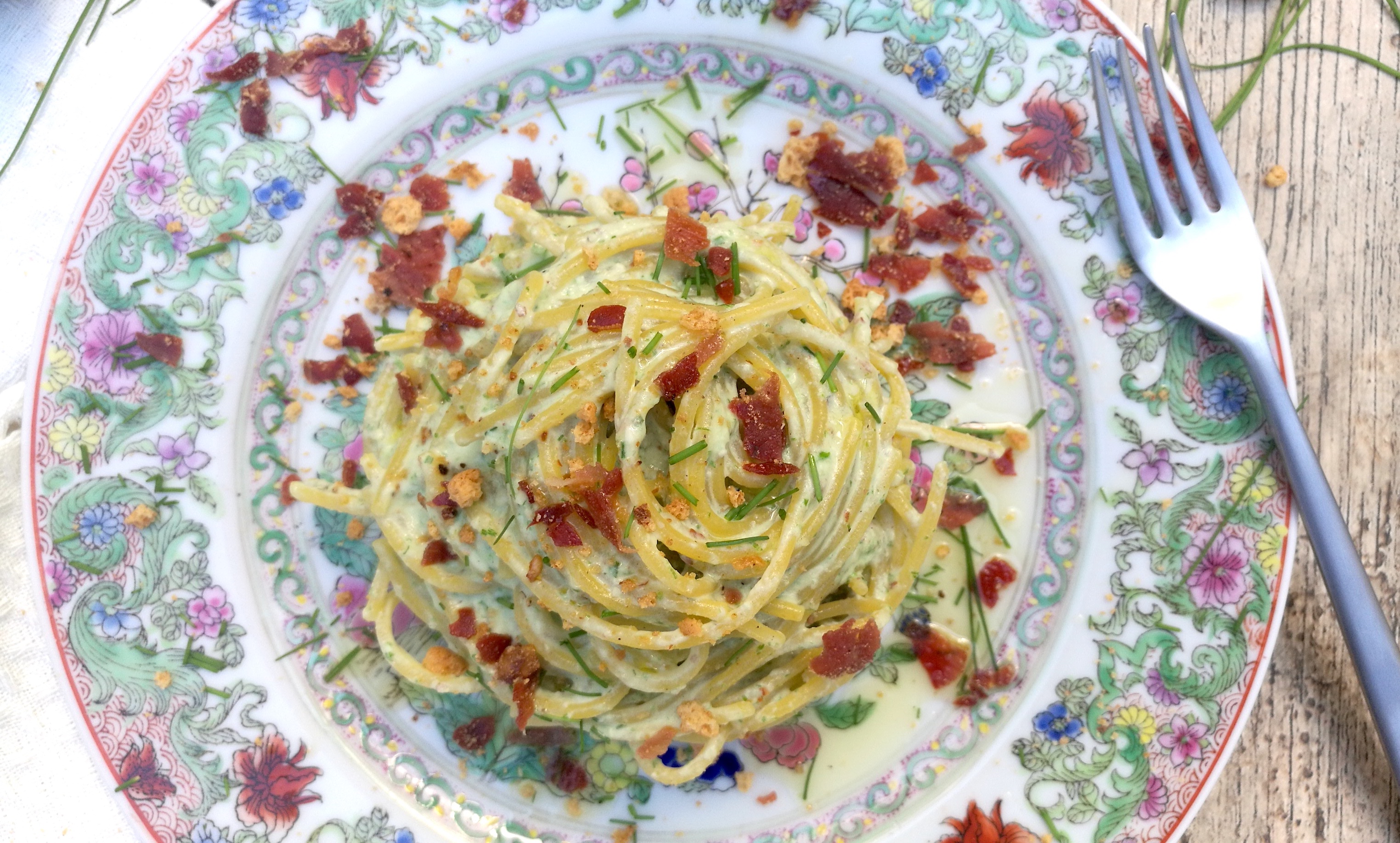 Spaghetti multicereali con pesto di erba cipollina, briciole di prosciutto crudo e amaretti